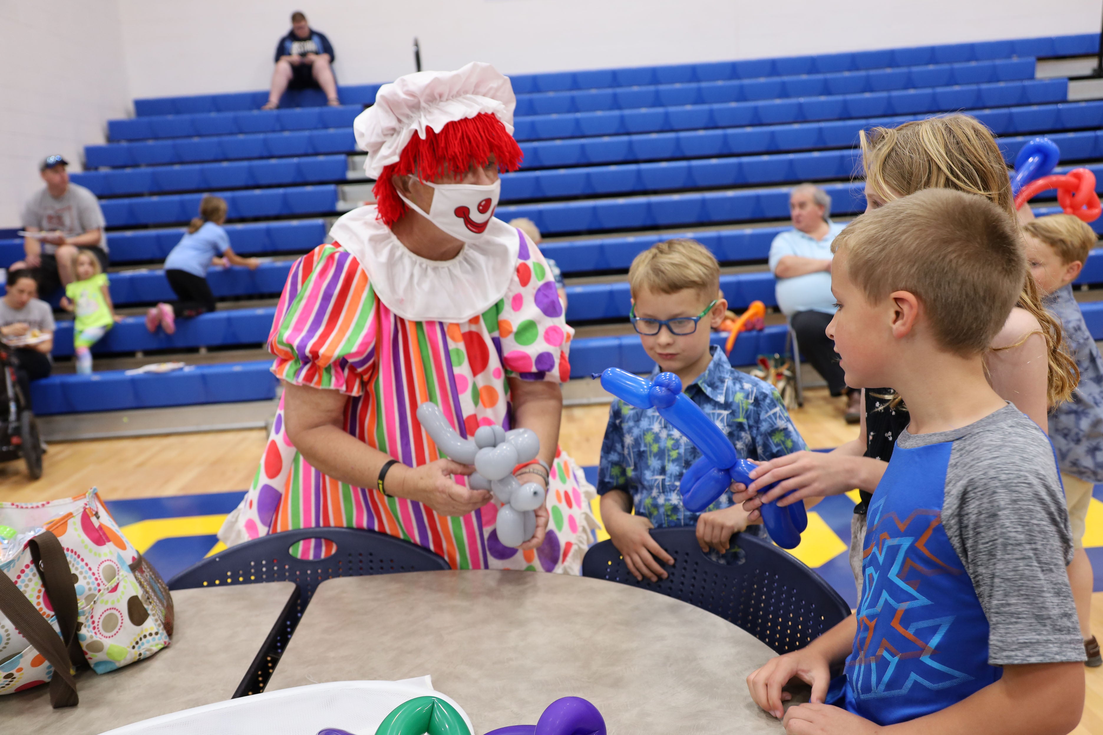 clowns blow up balloon hats for kids